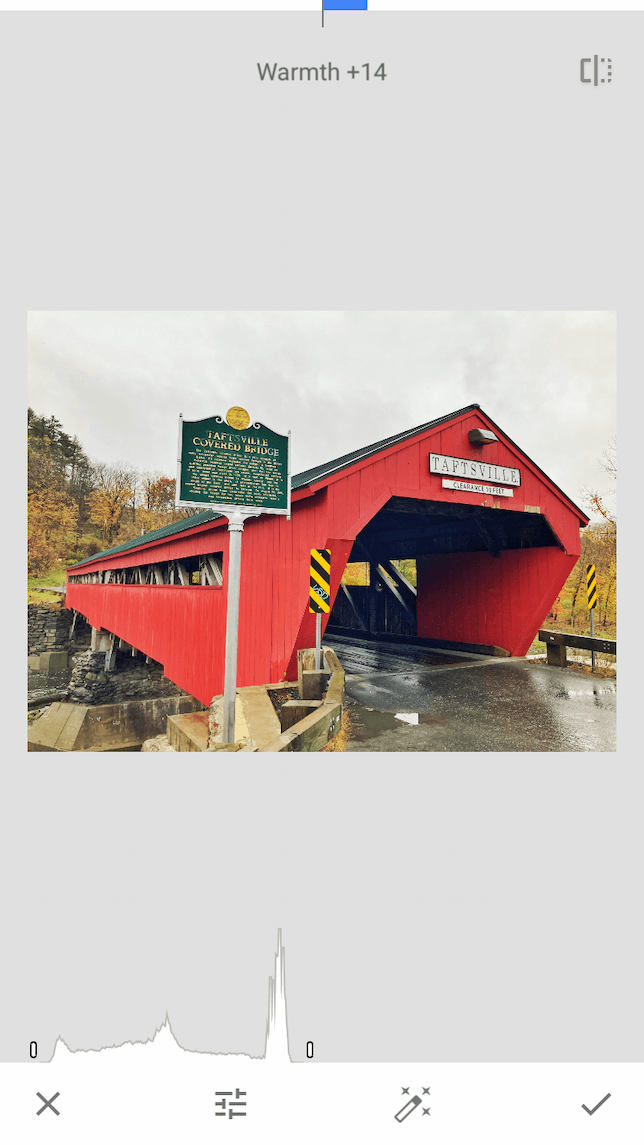 A screenshot of a red covered bridge demonstrating how to tune an image in Snapseed.