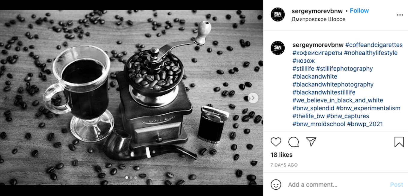 An Instagram screenshot featuring a black-and-white photo of a cup of coffee, a coffee grinder, and coffee beans.