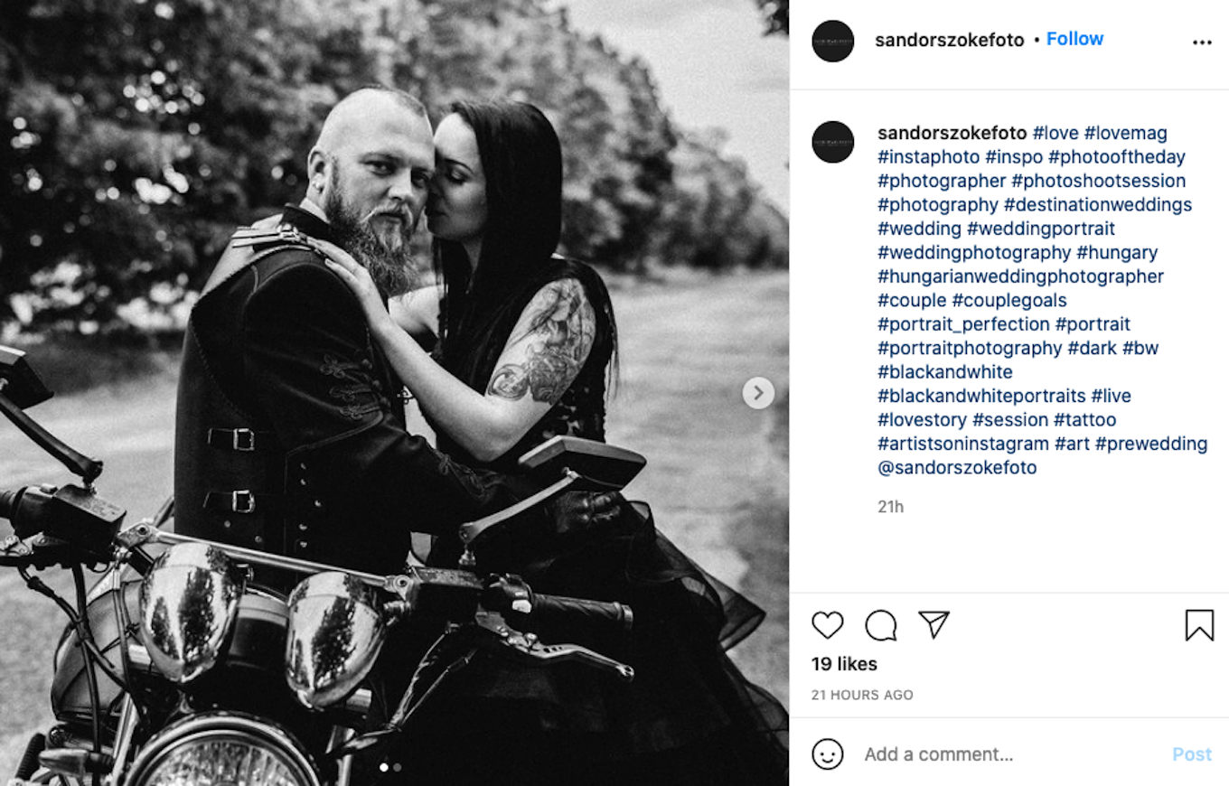 A black and white portrait of a man and a woman sitting together on a motorcycle.