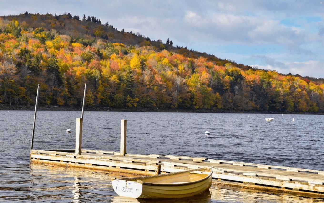 A photo of a small boat moored next to a dock, demonstrating the use of foreground, middle-ground, and background in photography.