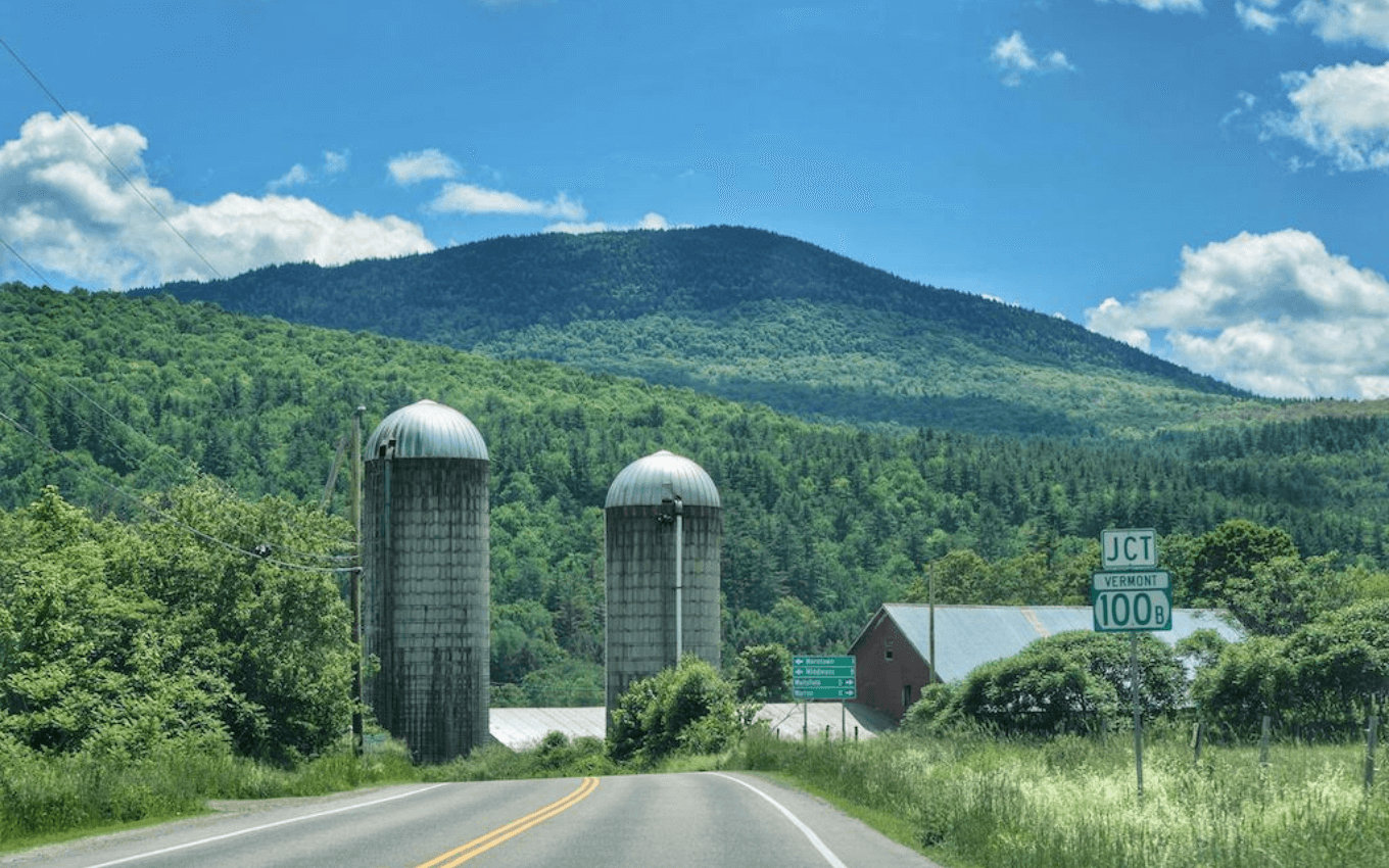 A photograph of a barn with silos in front of a country road, demonstrating leading lines in photography.