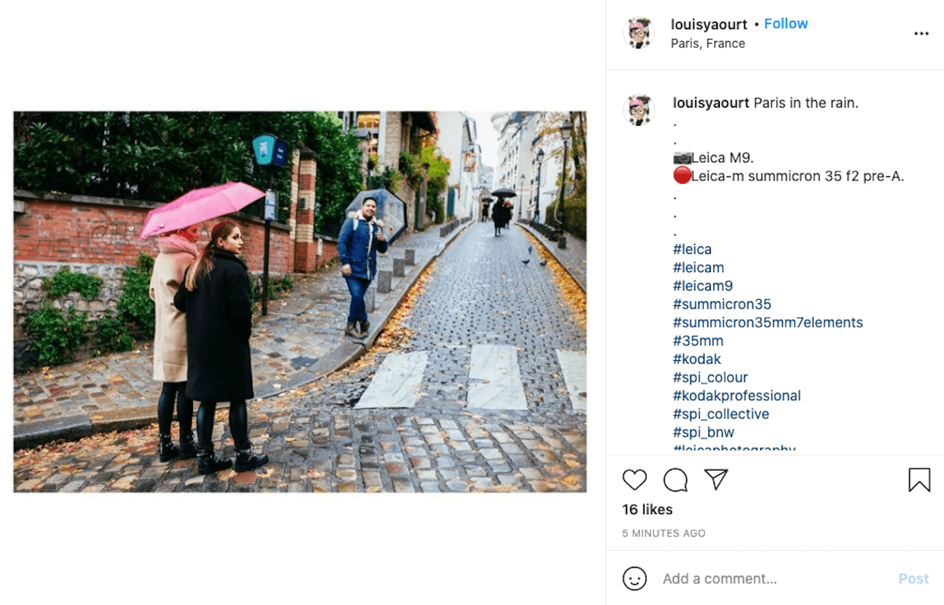 An Instagram screenshot showing several people walking with umbrellas in the rain.