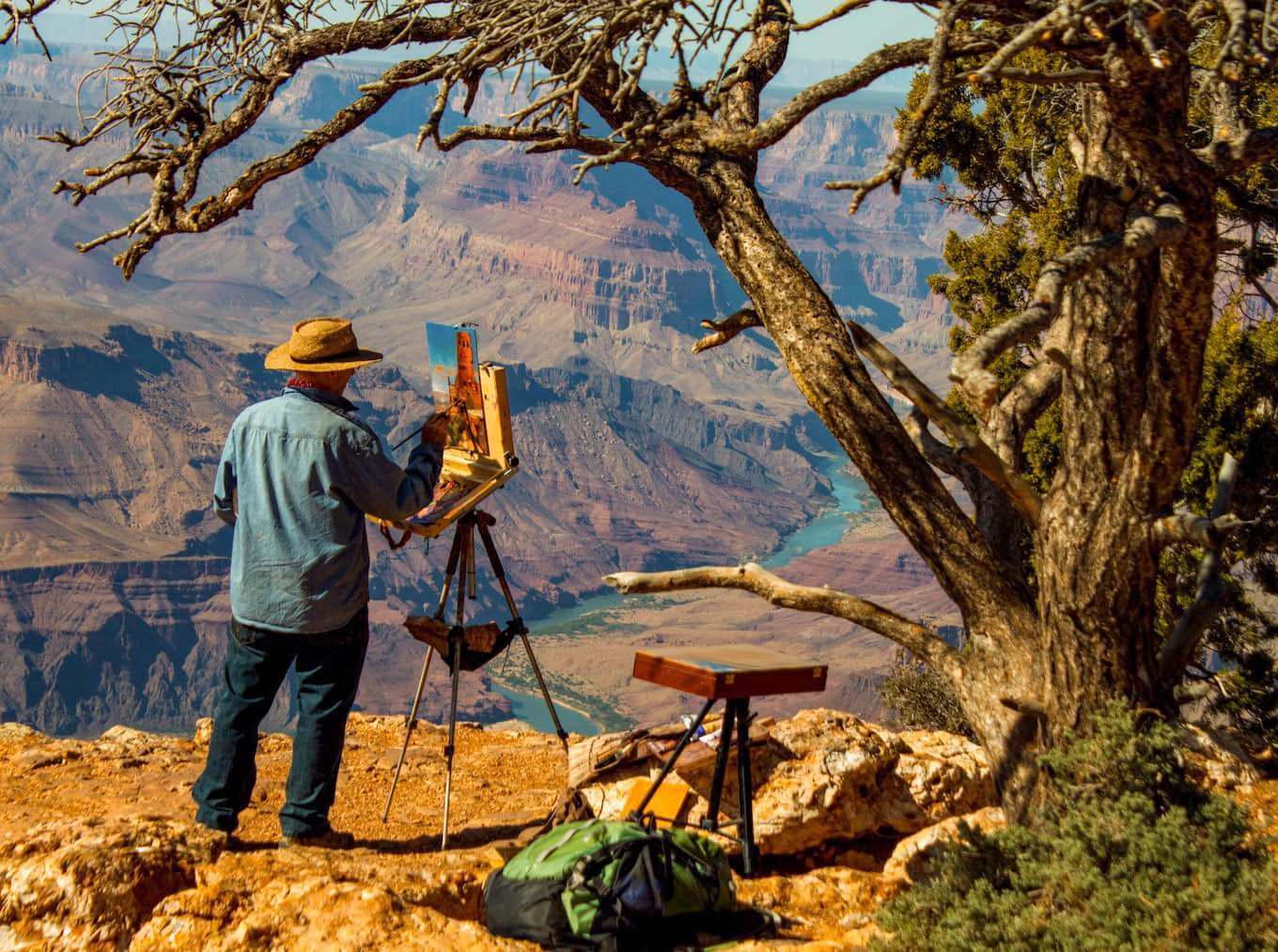 A person painting a picture at the Grand Canyon.